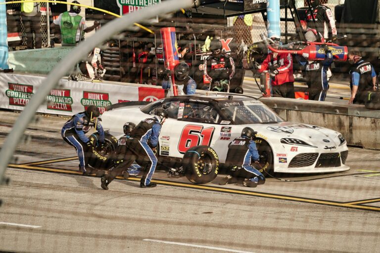 High-energy pit stop with a race car at a Miami NASCAR event.