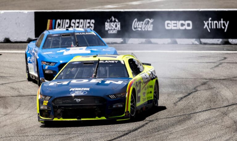 Nascar race cars speeding on a track, showcasing thrilling motorsport action.